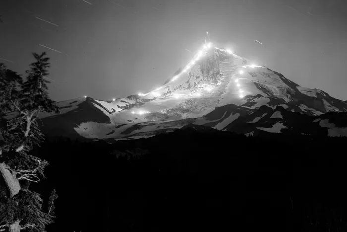 Black-and-white photograph: Night Skiers with Flares, Mt. Hood. Location: Mt. Hood, Oregon.
